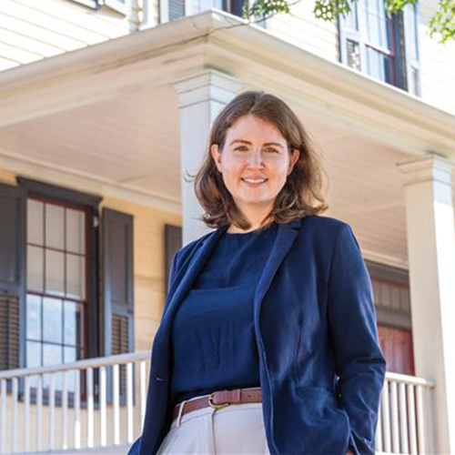 Woman standing in front of historic home