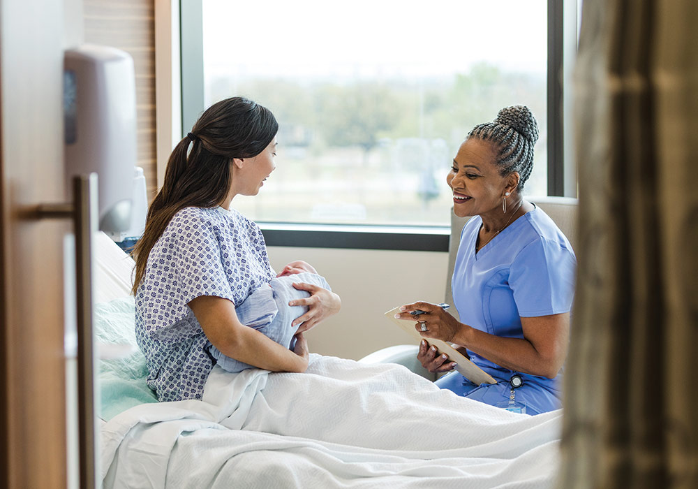 nurse sits with a woman and infant