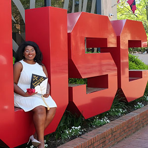 Ny'Kendria Elder sits on the USC letters on campus.