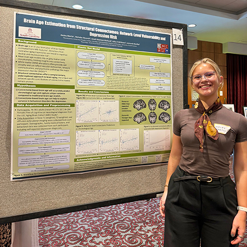 Ansley Martin stands next to her poster titled "Brain Age Estimation from Structural Outcomes: Network-Level Vulnerability and Depression Risk." Remaining poster text is not distinguishable.