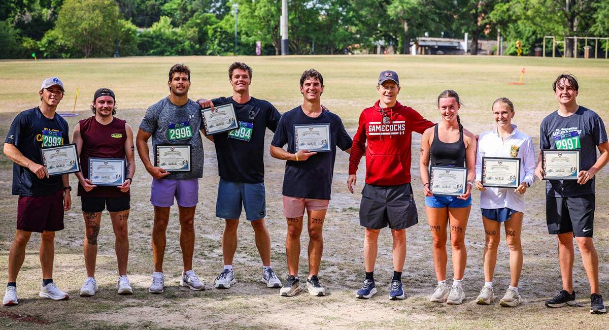 Joe Roof stands with a group of students with certificates of completion after the mini triathlon.