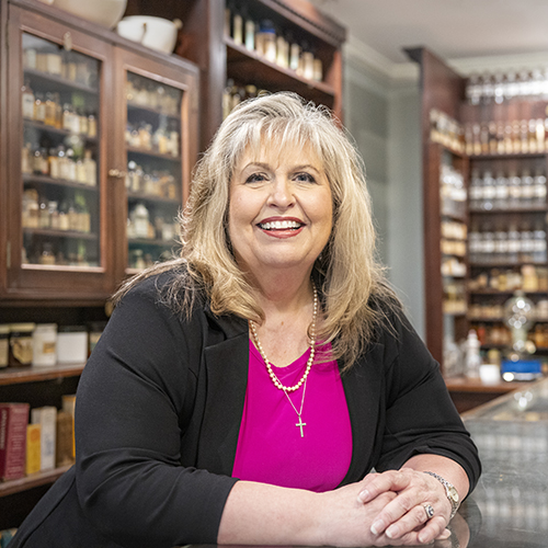 Kathy Moore poses inside the College of Pharmacy museum.