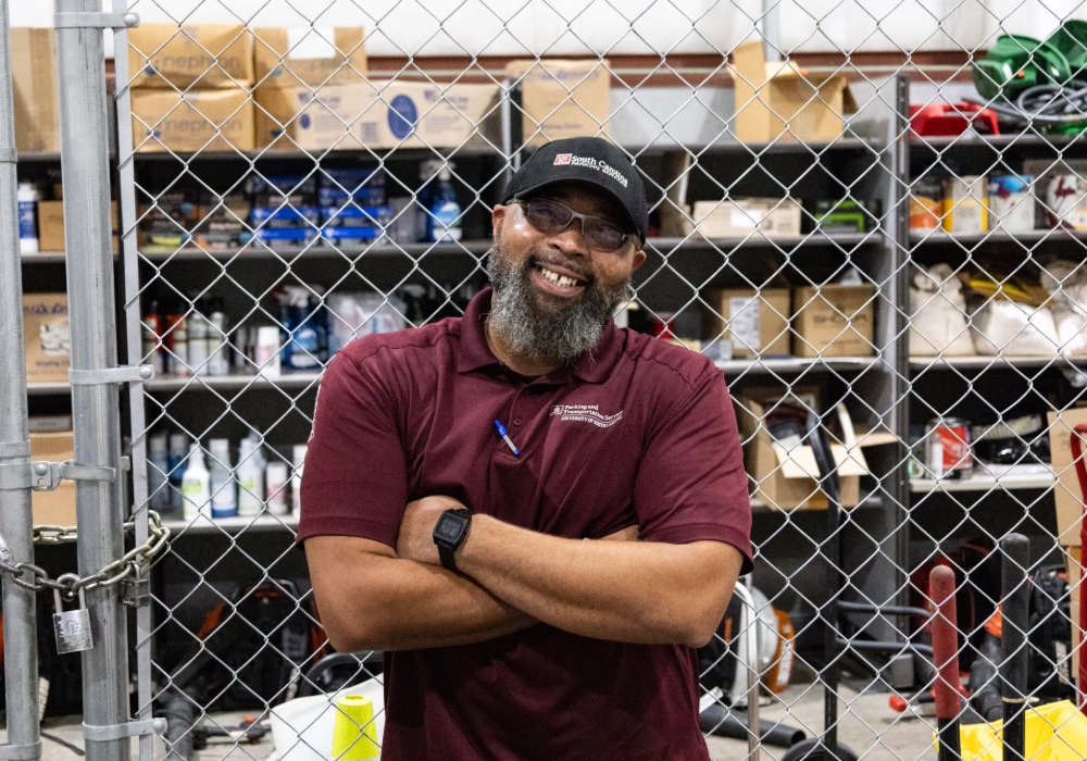 Kendall Barnes of USC Parking and Transportation services maintenance team stands in front of his cage of tools.