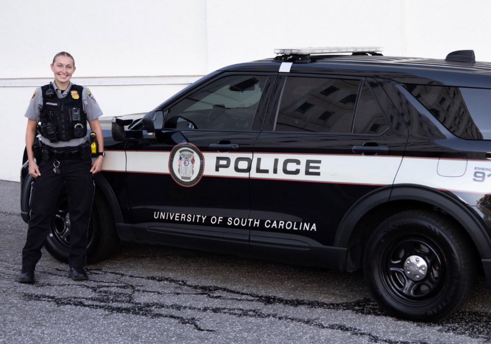 Officer Ava McGowan of the USCPD in front of her patrol car.